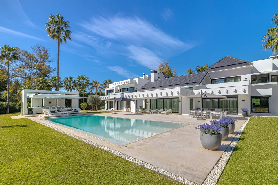 Fotografía de interiorismo y arquitectura de una villa moderna con piscina, amplias zonas ajardinadas en Guadalmina Baja
