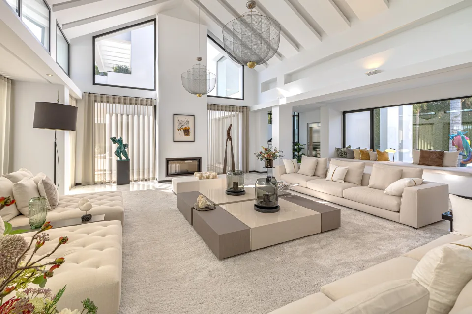 Fotografía de interiorismo y arquitectura de un amplio salón contemporáneo con sofás claros en Guadalmina Baja
