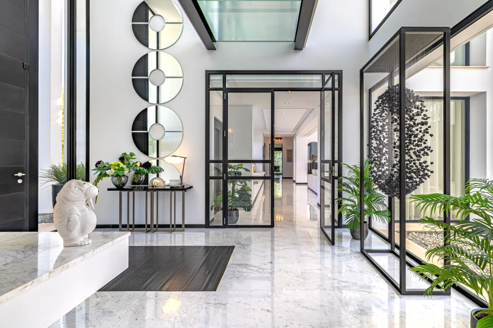 Fotografía de interiorismo y arquitectura de un elegante hall con suelos de mármol, paredes blancas en Guadalmina Baja