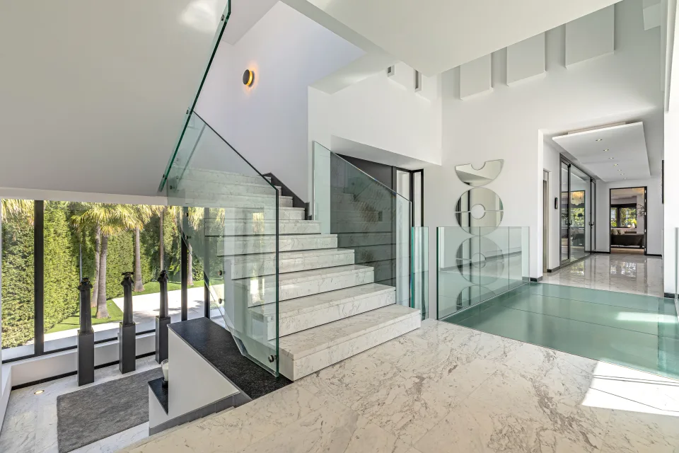 Fotografía de interiorismo y arquitectura de un elegante vestíbulo con escaleras de mármol en Guadalmina Baja