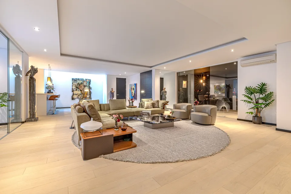 Fotografía de interiorismo y arquitectura de un amplio salón con sofá en forma de L, mesas de café elegantes en Guadalmina Baja