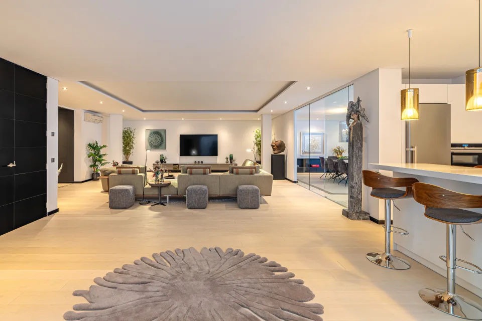 Fotografía de interiorismo y arquitectura de un amplio salón con sofás en tonos neutros, mesas de centro en Guadalmina Baja