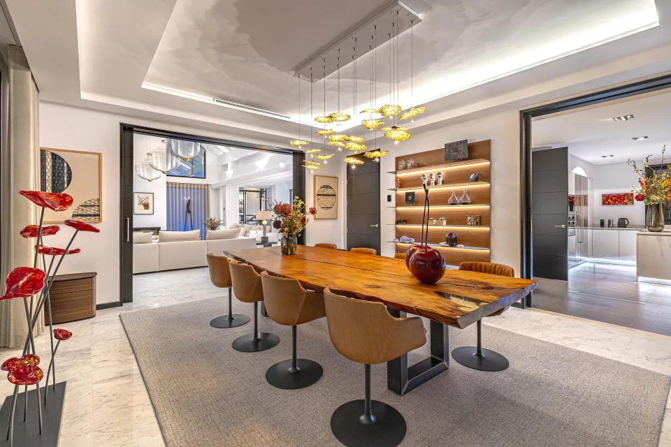 Fotografía de interiorismo y arquitectura de una elegante sala de comedor con mesa de madera, sillas de diseño en Guadalmina Baja