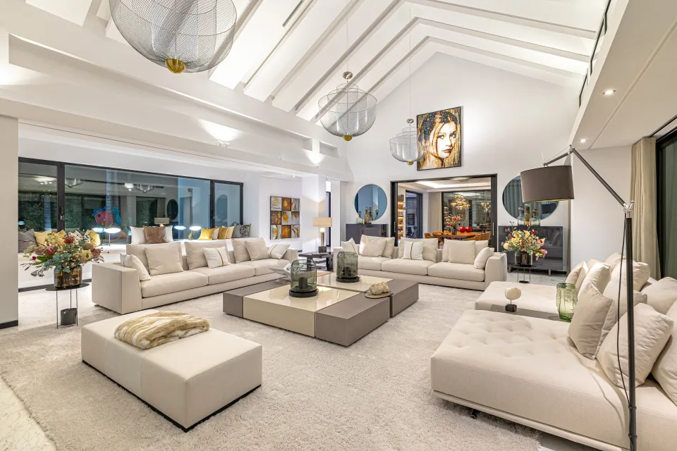 Fotografía de interiorismo y arquitectura de un espacioso salón con sofás claros, mesas bajas en Guadalmina Baja