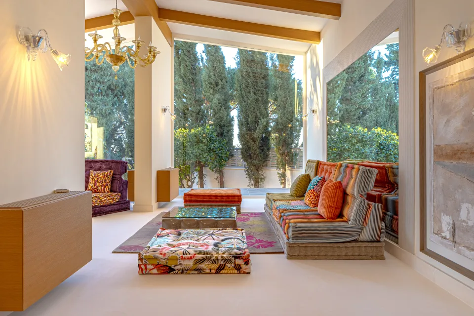 Real estate photograph of a bright living room with comfortable seating, decorated with colorful cushions in Marbella
