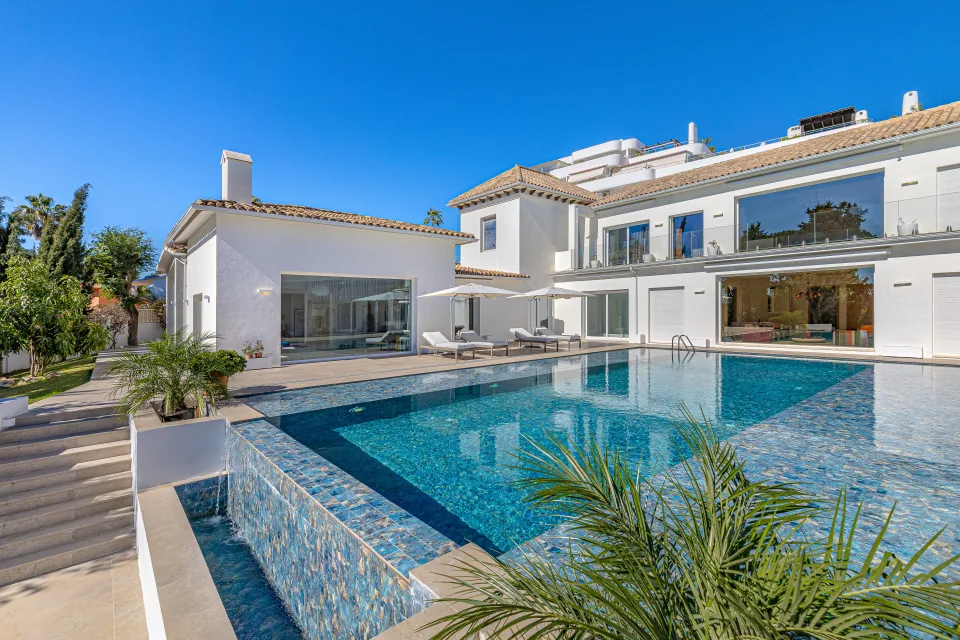 Fotografía inmobiliaria de una villa con piscina exterior, jardín bien cuidado y amplias terrazas en Marbella