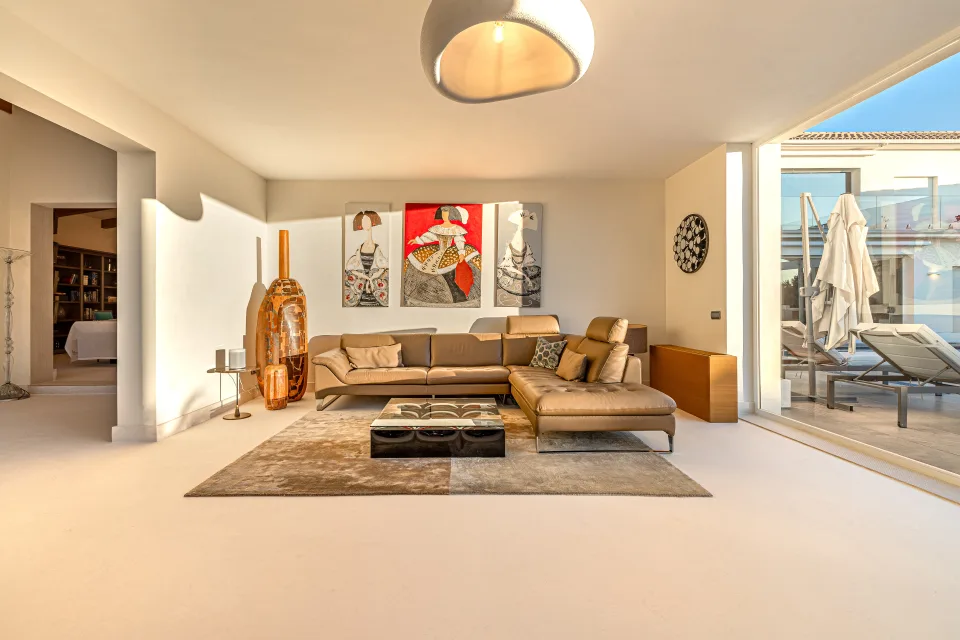 Fotografía inmobiliaria de un salón moderno con sofá de cuero claro, mesa de centro negra en Marbella