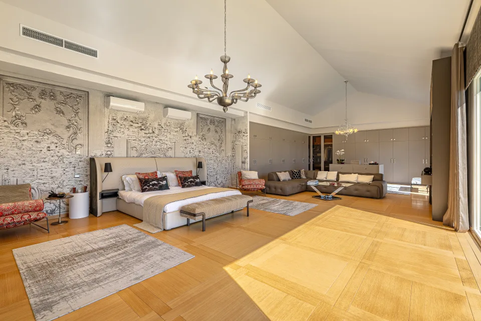Fotografía inmobiliaria de un amplio dormitorio con camas king size, mobiliario moderno y luz natural abundante en Marbella