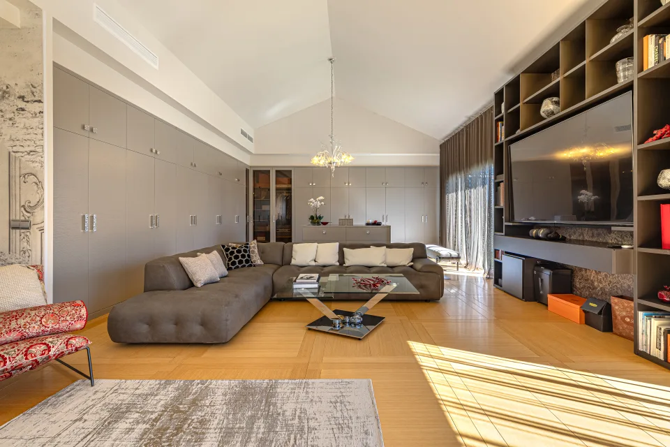 Fotografía inmobiliaria de un salón moderno con sofá de esquina, decoración elegante y luz natural abundante en Marbella