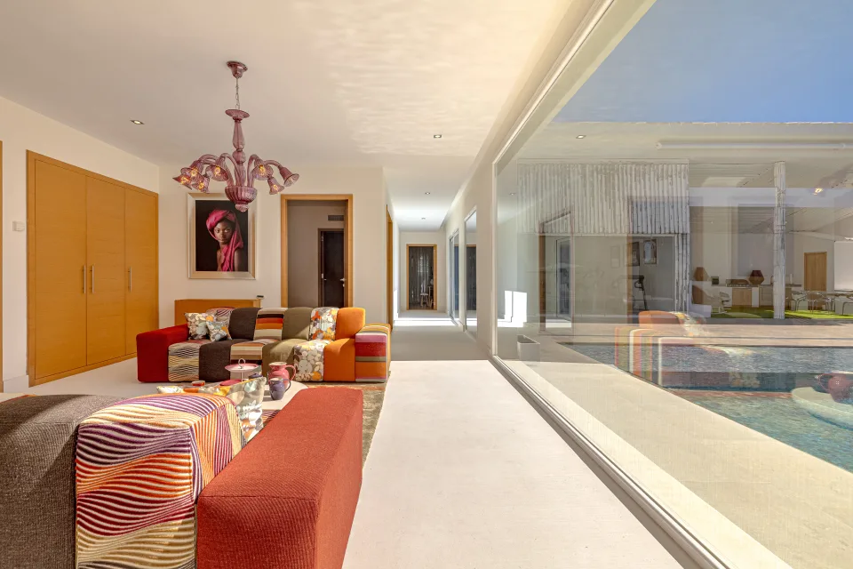 Fotografía inmobiliaria de un moderno salón con cómodos sofás coloridos y grandes ventanales que dan al exterior en Marbella