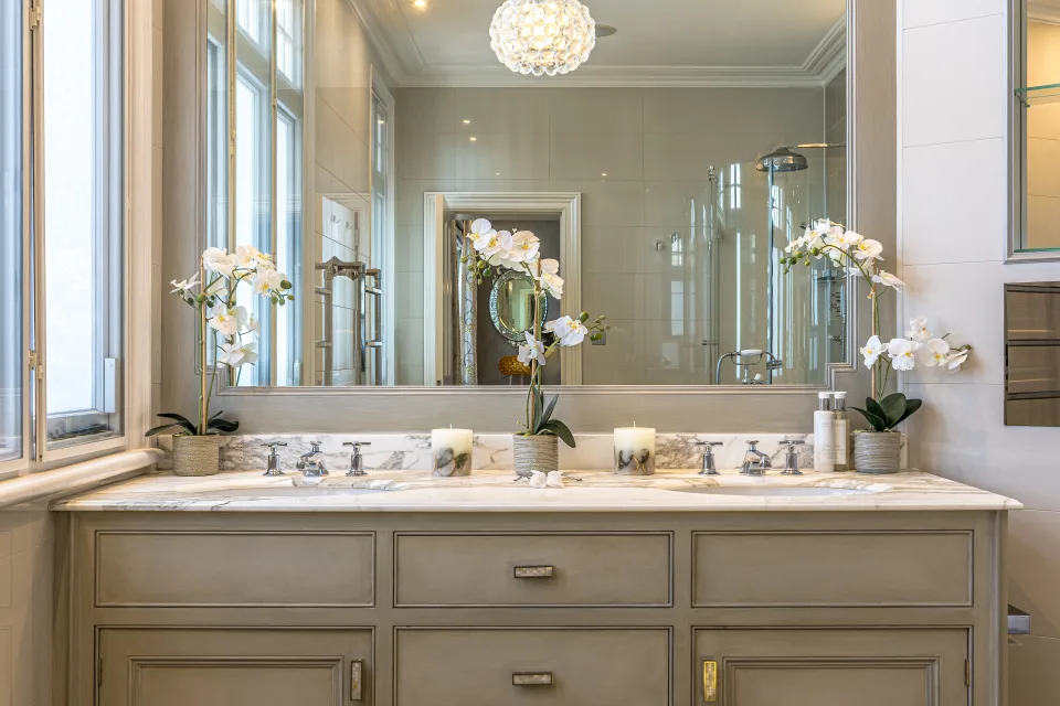 Fotografía inmobiliaria de un baño con lavabo doble, encimera de mármol y ventanales luminosos en Londres