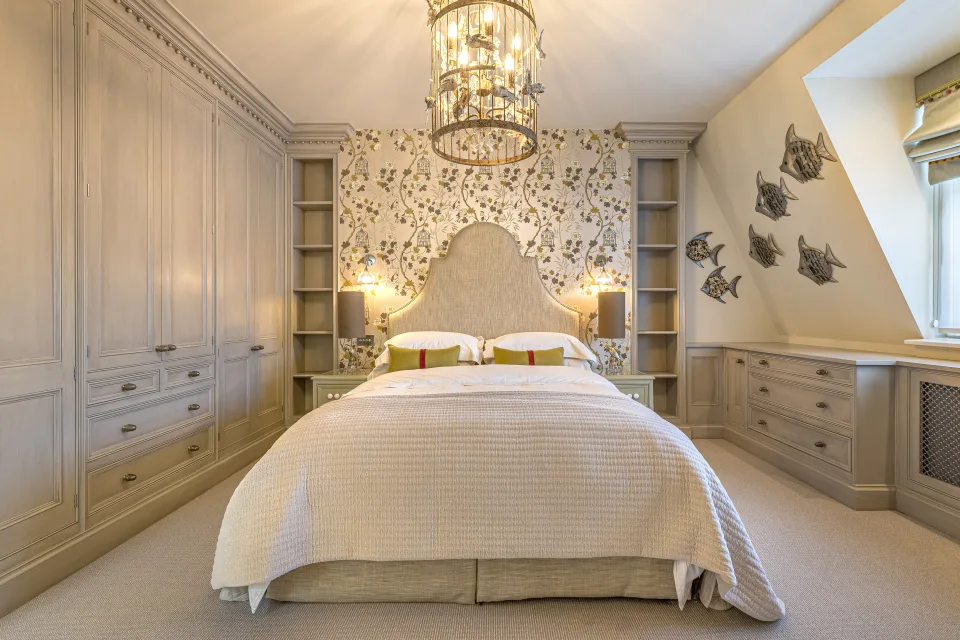 Real estate photograph of a bedroom featuring a double bed, fitted wardrobes and floral wallpaper in London