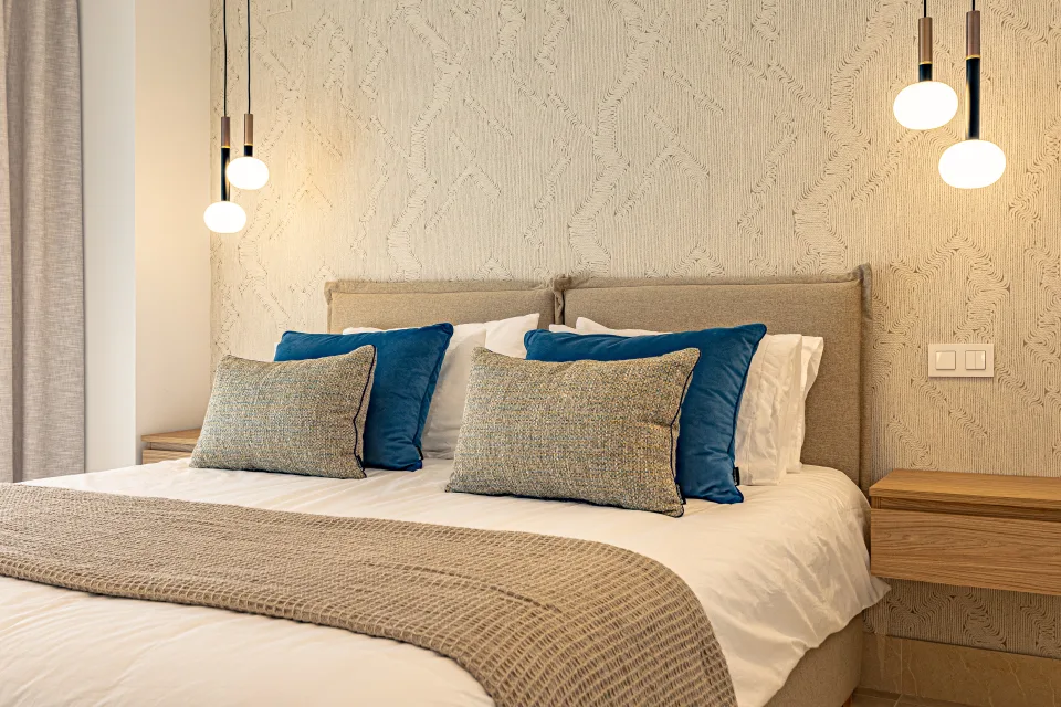 Interior design and architecture photograph of a stylish bedroom with a double bed, upholstered headboards in Sotogrande