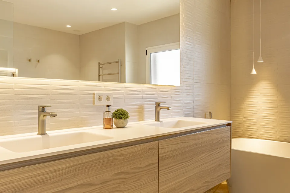 Interior design and architecture photograph of a minimalistic bathroom with double sink, modern faucets and integrated bathtub in Sotogrande